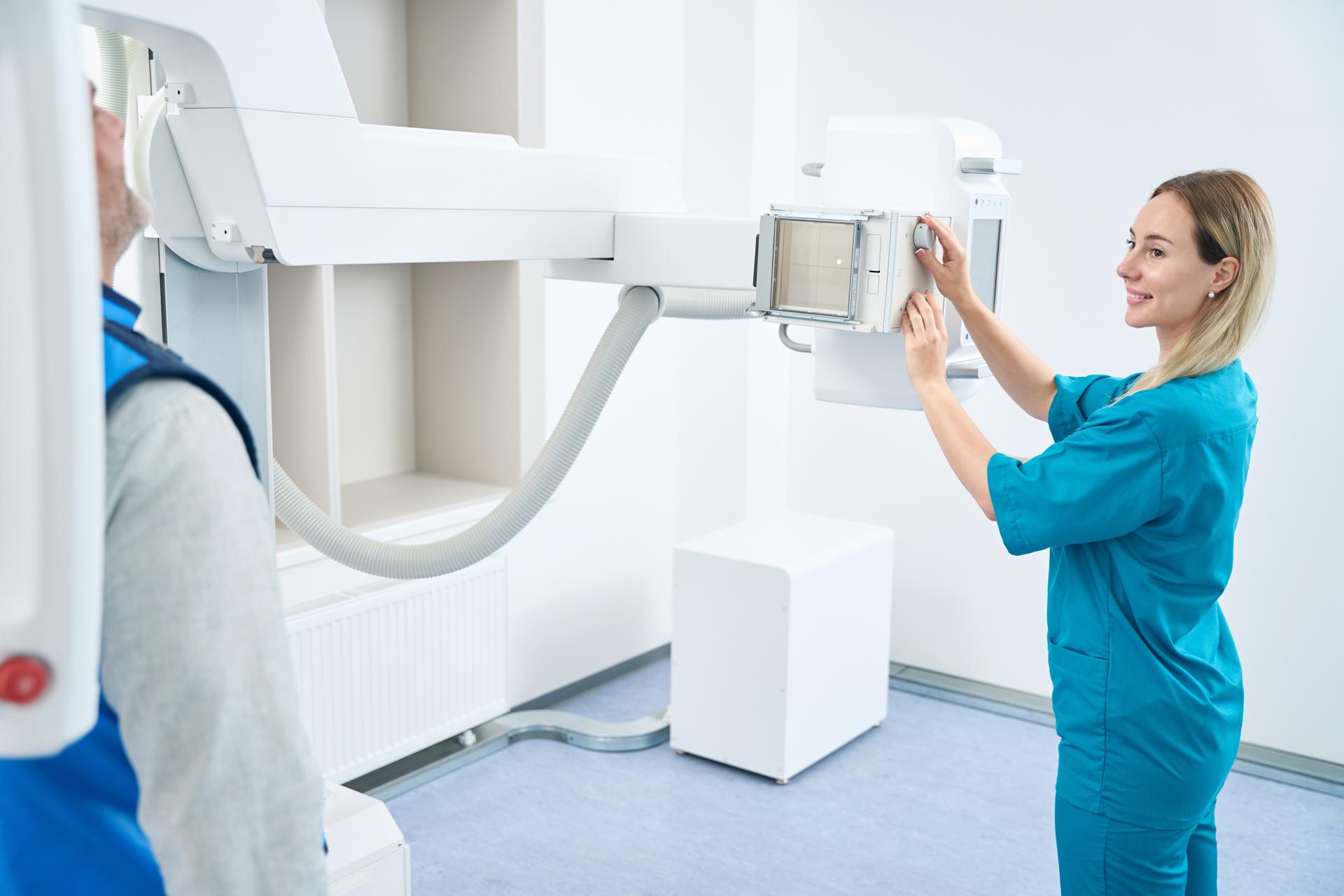 Woman doctor prepares patient for x-ray of head on machine